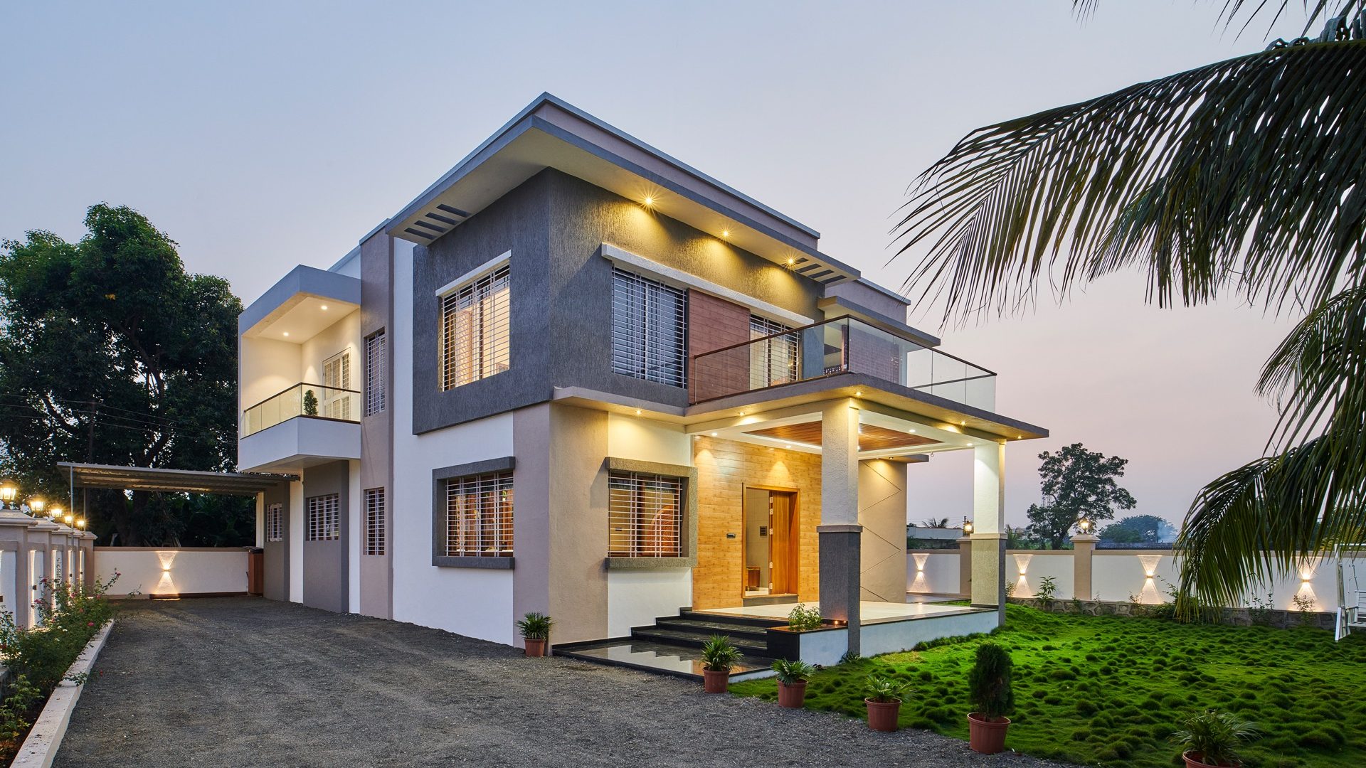 Contemporary grey-and-white bungalow with timber cladding and warm soffit lights at dusk — Mr. Dhananjay Gaikwad, Kondhanpuri
