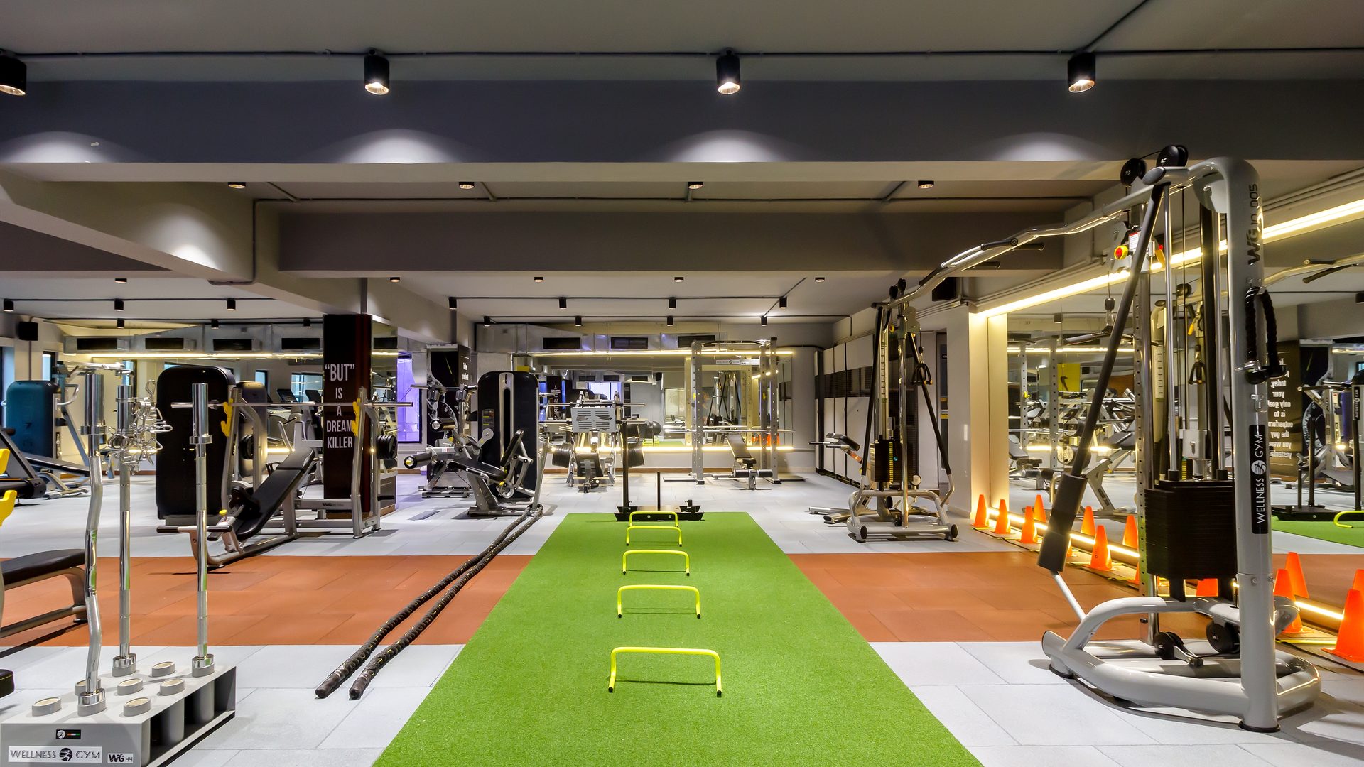 Training floor with a turf sprint strip, rubber flooring and mirror-lit walls — Dumbbell Bee fitness club