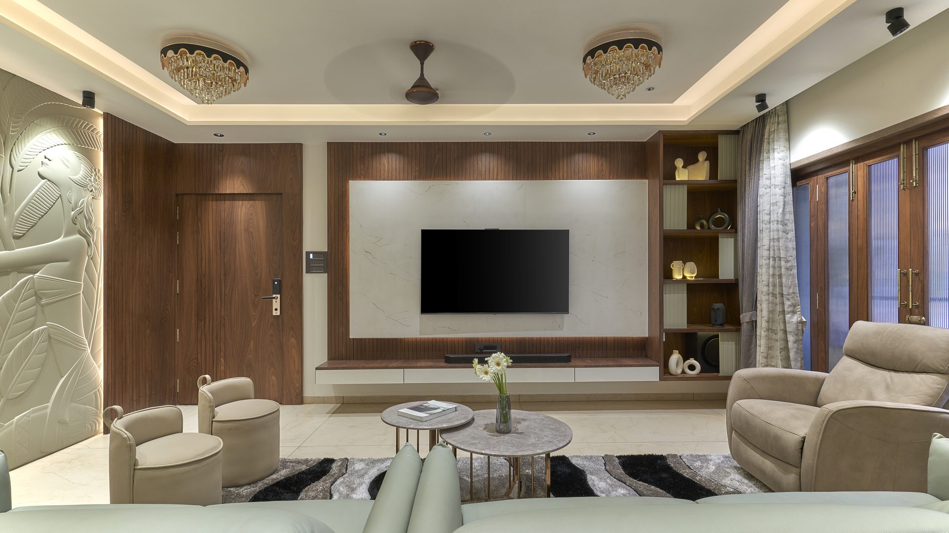 Symmetrical living room with crystal ceiling fixtures and a sculpted relief wall — Shreenivas