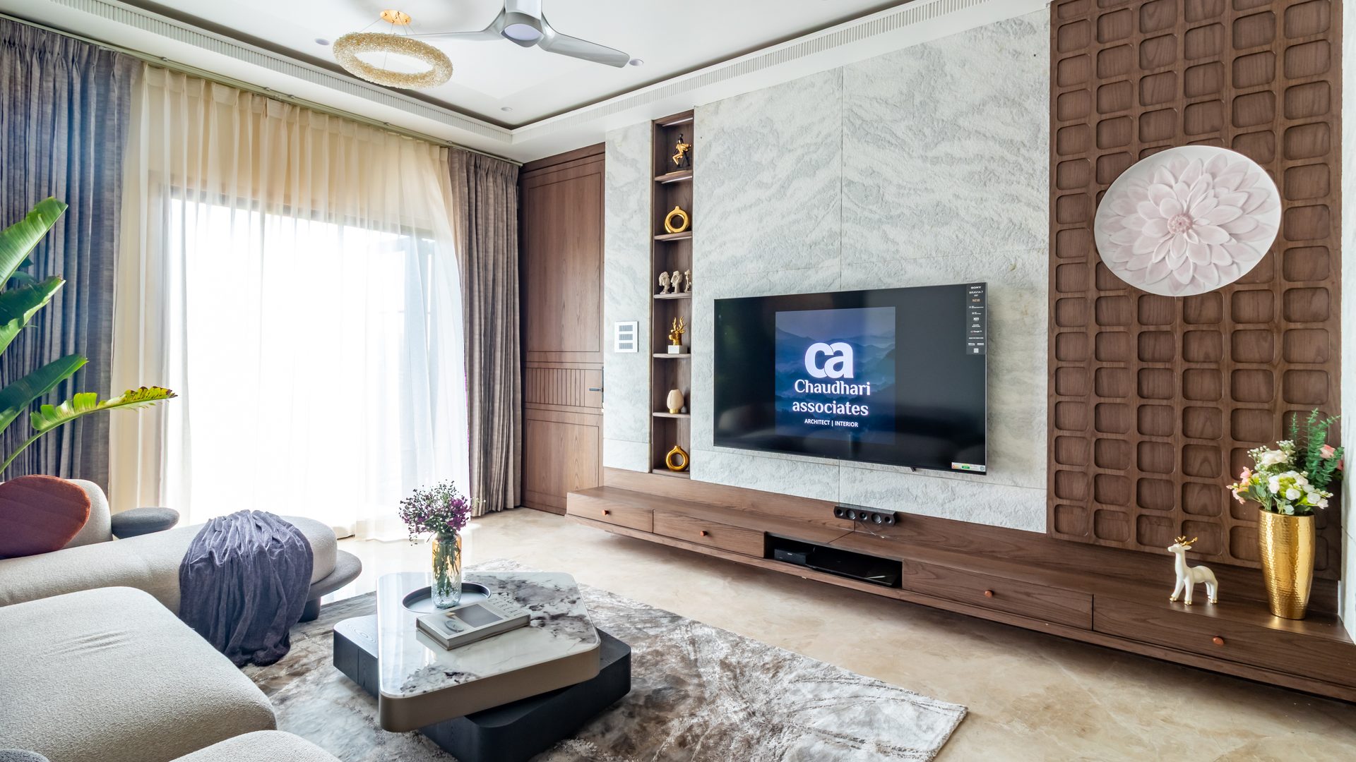 Sleek living room with a veined-marble TV wall and walnut panelling — Chandradev, Parner