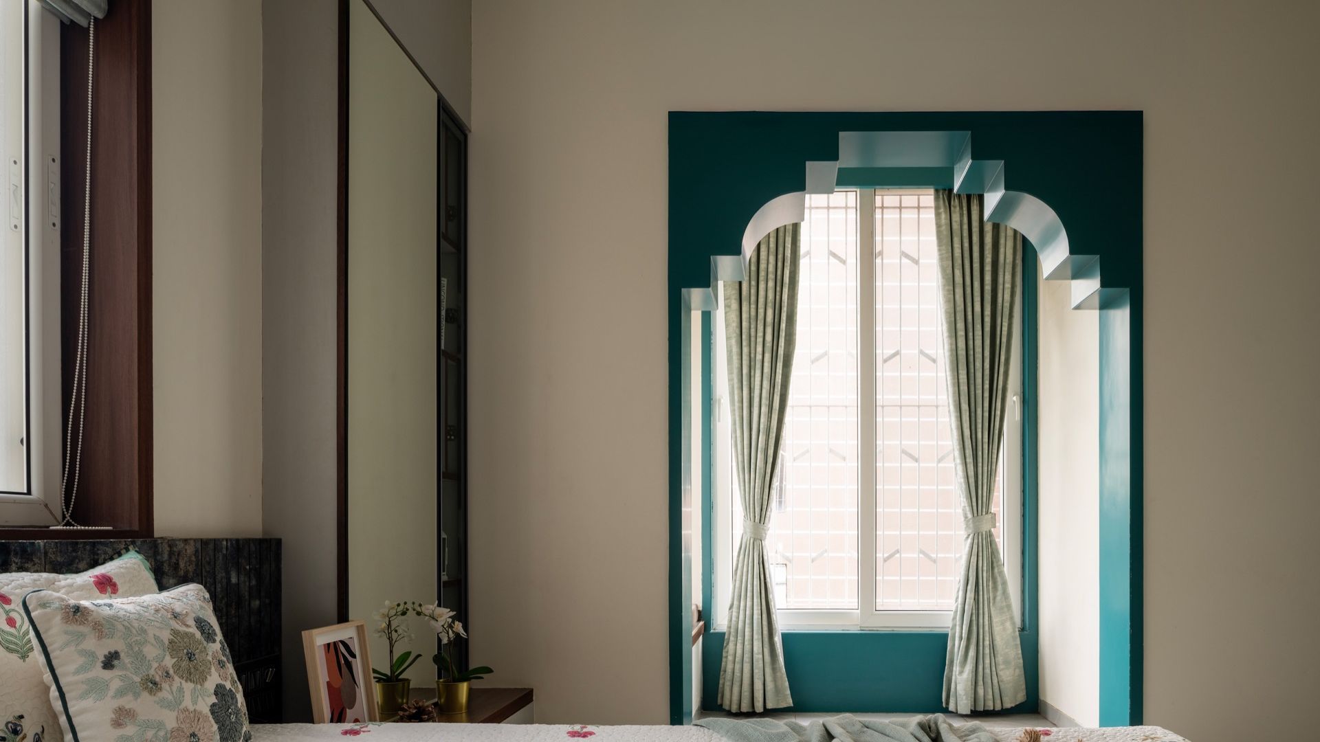 Teal stepped arch framing a window above a block-print bed — Cultural Contours & Modern Minimalisms