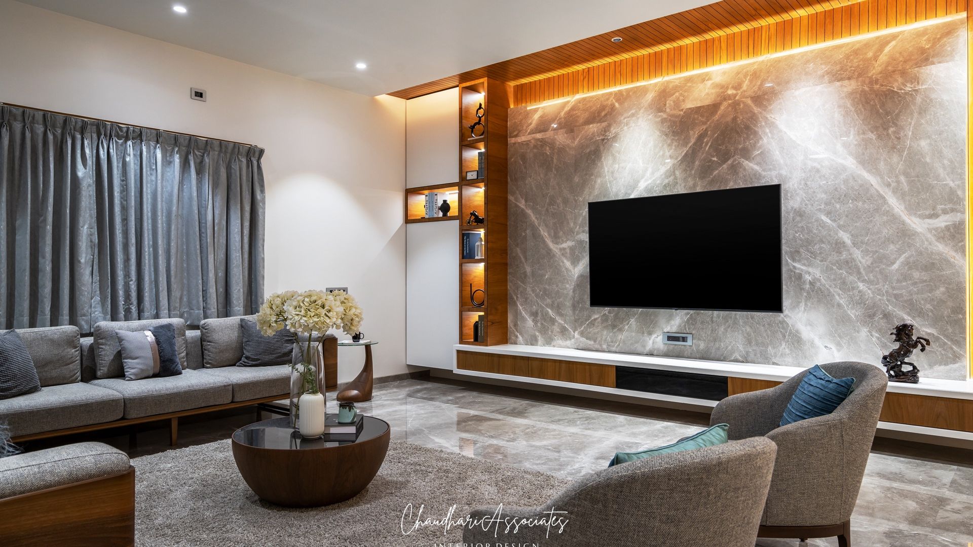 Living room with a glowing marble-and-teak TV wall — Gajlakshmi, Shirur