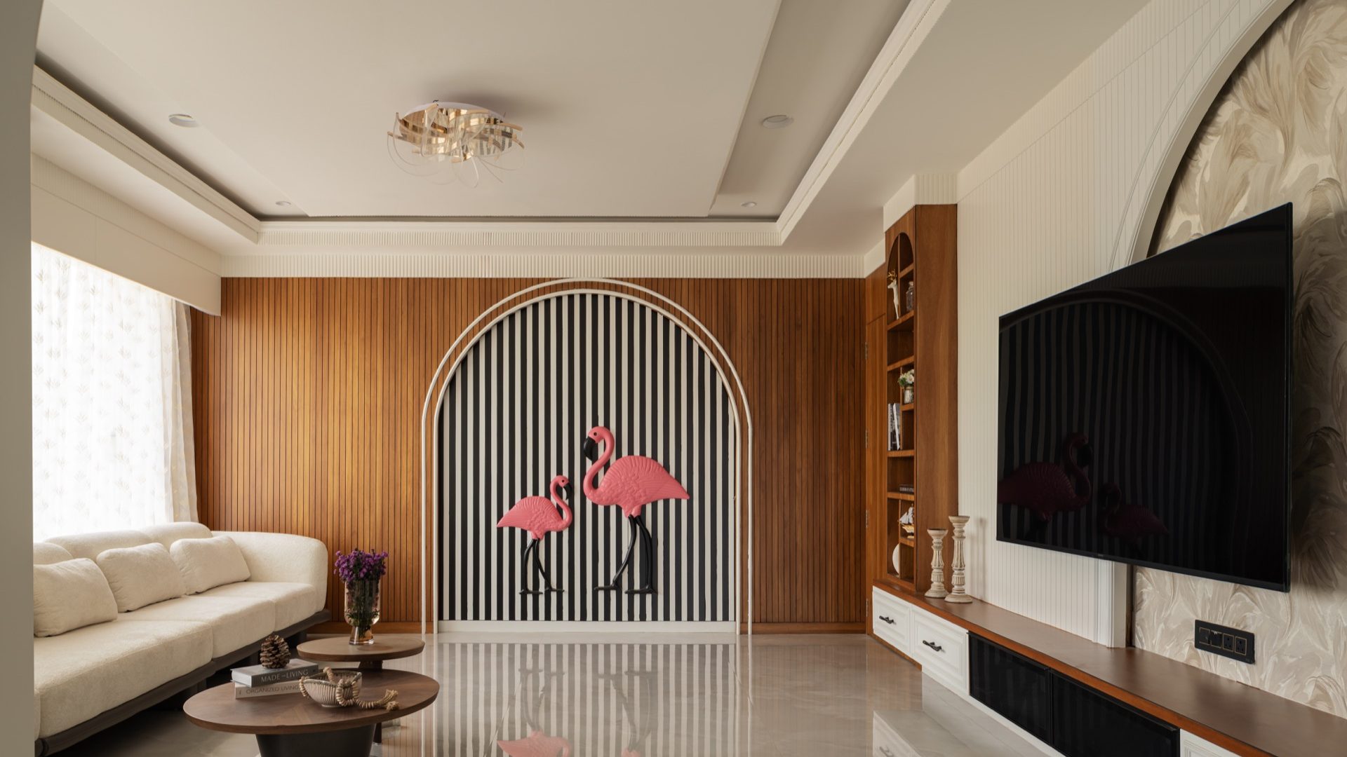 Living room with a striped arch and pink flamingo sculpture set into a timber-slatted wall — The Flamingo, Shirur